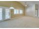 Bright living room with neutral paint, carpet flooring, and views into another room at 8204 Turbys Treehouse Pl, Las Vegas, NV 89131
