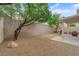 Backyard featuring drought tolerant landscaping, mature trees, and a covered patio at 8873 Happy Stream Ave, Las Vegas, NV 89143