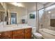 Bright bathroom features a modern vanity, framed mirror, and glass-enclosed shower-tub combination at 9496 Wild Valley Ave, Las Vegas, NV 89148