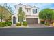 Charming two-story home with a brick driveway, landscaped yard, and a two car garage at 9496 Wild Valley Ave, Las Vegas, NV 89148