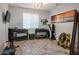 Well-equipped home gym features various workout equipment, colorful patterned rug, and large window for natural light at 9496 Wild Valley Ave, Las Vegas, NV 89148