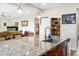 Kitchen island with a sink and granite countertop, opening into a dining and living area at 9496 Wild Valley Ave, Las Vegas, NV 89148