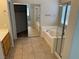 Relaxing bathroom with a separate tub and shower, mirrored closet doors, and tile flooring at 10195 Queensbury Ave, Las Vegas, NV 89135