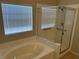 Bright bathroom featuring a soaking tub and glass-enclosed shower at 10195 Queensbury Ave, Las Vegas, NV 89135