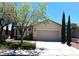 Charming single-story home featuring a well-manicured lawn, mature trees, and a two-car garage at 10195 Queensbury Ave, Las Vegas, NV 89135