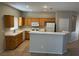 Bright kitchen featuring wooden cabinets, white appliances, tile floors, and a convenient breakfast bar at 10195 Queensbury Ave, Las Vegas, NV 89135