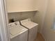 Practical laundry room with washer, dryer, and built-in shelving at 10195 Queensbury Ave, Las Vegas, NV 89135