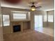 Comfortable living room featuring a warm fireplace, neutral colors, tile and carpet flooring, and ceiling fan at 10195 Queensbury Ave, Las Vegas, NV 89135