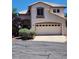 Charming two-story home showcasing a two-car garage, a tile roof, and desert landscaping at 10400 Beachwalk Pl, Las Vegas, NV 89144