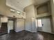 Open-concept living area with high ceilings, showcasing the staircase, and laminate flooring at 10400 Beachwalk Pl, Las Vegas, NV 89144