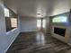 Open-concept living space with dark laminate floors, natural light, and a cozy fireplace at 10400 Beachwalk Pl, Las Vegas, NV 89144