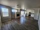 Spacious living room with dark laminate floors, fireplace, and an adjacent kitchen at 10400 Beachwalk Pl, Las Vegas, NV 89144