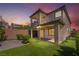 The backyard has a cozy patio, green turf, and a putting green for entertainment and relaxation at 10793 Pastel Sunset Ct, Las Vegas, NV 89135