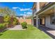 Home's backyard features manicured lawn with shrubbery at 10793 Pastel Sunset Ct, Las Vegas, NV 89135