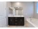 Elegant bathroom featuring a double sink vanity and a soaking tub for relaxation at 10793 Pastel Sunset Ct, Las Vegas, NV 89135