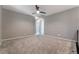 Spacious carpeted bedroom with a ceiling fan and neutral paint offers a relaxing atmosphere at 10793 Pastel Sunset Ct, Las Vegas, NV 89135