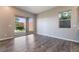 Bright living room featuring wood-look flooring, a sliding glass door to the backyard, and a window at 10793 Pastel Sunset Ct, Las Vegas, NV 89135