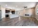 Open concept living space with modern electric fireplace, a ceiling fan, and dark cabinets in kitchen at 10793 Pastel Sunset Ct, Las Vegas, NV 89135