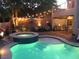 Backyard with a pool, spa, lush landscaping, and patio seating with string lights at 11219 Playa Bonita Ave, Las Vegas, NV 89138