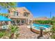 Backyard with a pool, spa, stone patio, and a two-story home at 11219 Playa Bonita Ave, Las Vegas, NV 89138