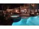 Backyard with a pool, spa, stone patio, and lounge area with string lights at 11219 Playa Bonita Ave, Las Vegas, NV 89138