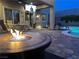 Outdoor firepit and a seating area next to a pool with a television at 11219 Playa Bonita Ave, Las Vegas, NV 89138