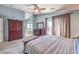 Light and airy main bedroom with carpet floors, ceiling fan, and walk out patio access through brown curtains at 11219 Playa Bonita Ave, Las Vegas, NV 89138