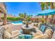 Relaxing patio with seating, surrounded by lush landscaping and a beautiful pool at 11219 Playa Bonita Ave, Las Vegas, NV 89138