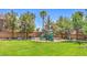 Community playground featuring green slides surrounded by trees within a lush green park at 11219 Playa Bonita Ave, Las Vegas, NV 89138