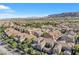 An aerial view showcases a meticulously planned community with neatly arranged homes against a scenic mountain backdrop at 11420 Ogden Mills Dr # 101, Las Vegas, NV 89135