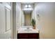 Cozy half-bathroom with a large mirror and vanity, adjacent to the laundry room at 11420 Ogden Mills Dr # 101, Las Vegas, NV 89135
