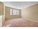 Spacious carpeted room with bright windows, neutral paint, and potential for versatile use at 11420 Ogden Mills Dr # 101, Las Vegas, NV 89135