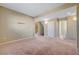 Spacious living room with neutral carpet and walls, leading to the staircase and hallway at 11420 Ogden Mills Dr # 101, Las Vegas, NV 89135
