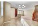 Open concept living area with neutral walls, tile flooring, staircase, and ample natural light at 11420 Ogden Mills Dr # 101, Las Vegas, NV 89135