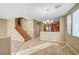 Open living area features tile flooring, a staircase, and an adjacent kitchen with stainless steel appliances at 11420 Ogden Mills Dr # 101, Las Vegas, NV 89135