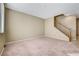 Spacious living room featuring neutral carpet, light beige walls, and a staircase at 11420 Ogden Mills Dr # 101, Las Vegas, NV 89135