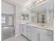 Elegant bathroom featuring double vanity with white cabinets, and a large mirror at 117 Destiny Orchard Ct, Henderson, NV 89011