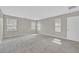 Spacious bedroom with plush gray carpeting, three large windows offering abundant natural light at 117 Destiny Orchard Ct, Henderson, NV 89011