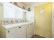 Functional laundry room with washer, dryer, overhead storage, and exterior door at 1220 Basin Brook Dr, North Las Vegas, NV 89032