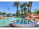 Relaxing hot tub with stone surround, steps, and serene pool views amidst tropical landscaping at 1700 Red Rock St, Las Vegas, NV 89146