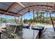 Covered outdoor kitchen and dining area with views of the pool and tennis court at 1700 Red Rock St, Las Vegas, NV 89146