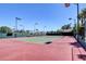 Full-size private tennis court with lighting and surrounded by lush landscaping and trees at 1700 Red Rock St, Las Vegas, NV 89146