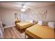 Bedroom with two beds, ceiling fan, mirrored closet doors, and bright natural light at 2043 Sombrero Dr, Las Vegas, NV 89169