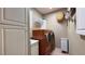 Spacious laundry room with cabinets, modern washer/dryer, and decorative basket for a functional space at 2050 W Warm Springs Rd # 4211, Henderson, NV 89014