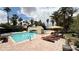 Beautiful community pool with lounge chairs, umbrellas, bridge, and lush landscaping at 2050 W Warm Springs Rd # 4211, Henderson, NV 89014