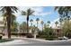 Gated community entrance with mature trees, palm trees, landscaping, and guard house at 2050 W Warm Springs Rd # 4211, Henderson, NV 89014
