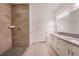 Bathroom features a shower with tile walls, double vanity with granite countertop, and white cabinets at 2071 Idaho St, Pahrump, NV 89048