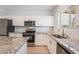 Bright kitchen boasts stainless steel appliances, granite countertops, white cabinets, and mosaic tile backsplash at 2071 Idaho St, Pahrump, NV 89048
