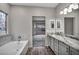 Bathroom featuring a soaking tub, granite countertops, and vanity with decorative lighting at 2124 Rising Mist St, Las Vegas, NV 89134