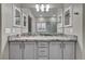 Bathroom vanity with a granite countertop, gray cabinetry, and a large mirror at 2124 Rising Mist St, Las Vegas, NV 89134